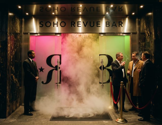 Walker's Court at night: the Soho Revue Bar doors open on dry ice, a doorman, men in suits smoking by the rope.